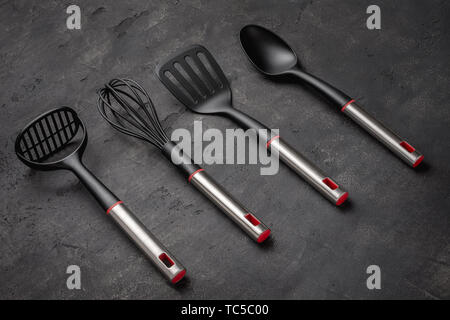 Modern Black Plastic Kitchen Utensils on Dark Background Stock Photo