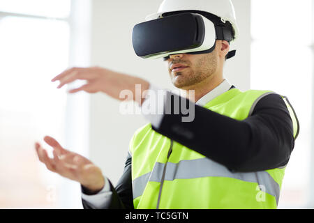 Waist up portrait of Middle-Eastern engineer building 3D model in VR, copy space Stock Photo