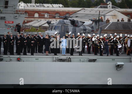 Defence Secretary Penny Mordaunt (left) First Sea Lord and Chief of Naval staff Admiral Sir Philip Jones and Prime Minister Theresa May stand on the deck of HMS Queen Elizabeth as they wave off veterans aboard the MV Boudicca, as it sails out of Portsmouth Harbour for the he Port of Le Havre in France as part of the commemorations for the 75th anniversary of the D-Day landings. Stock Photo