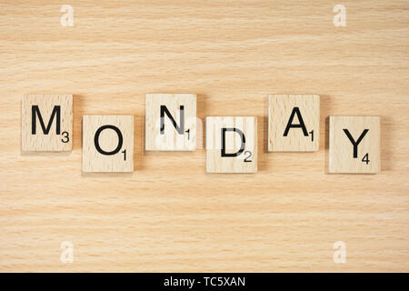 WORD MONDAY. Wooden letters spelling the word MONDAY on white ...