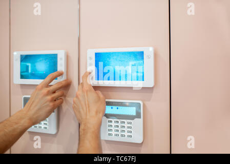 Workman setting up the video on the intercom near the entrance at home, close-up Stock Photo