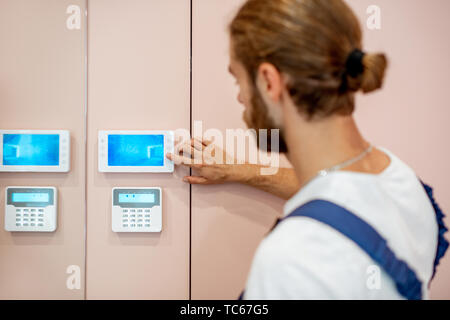 Workman setting up the video on the intercom near the entrance at home Stock Photo