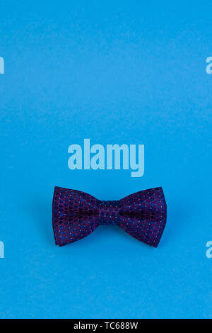 Purple bow-tie on blue background with copyspace. Happy fathers day concept. Minimalistic design Stock Photo