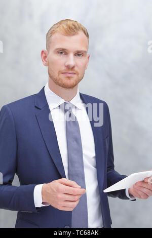 Modern portrait of an adult man with tablet computer, insurance agent, bank advisor or tax consultant. Stock Photo