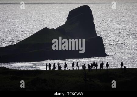 Gower, Swansea, Wales, UK. 5th June 2019. Weather: (note atmospheric distortion) Walkers and  sightseers enjoyed a beautiful sunny evening at National Trust Rhosili (correct,1's') on the Gower peninsula, south Wales. The headland and limestone clifftops afford spectacular views of Rhossili (correct, 2's') Bay and the iconic promontory of Worms Head. Showery conditions are forecast.  Credit: Gareth Llewelyn/Alamy Live News Stock Photo