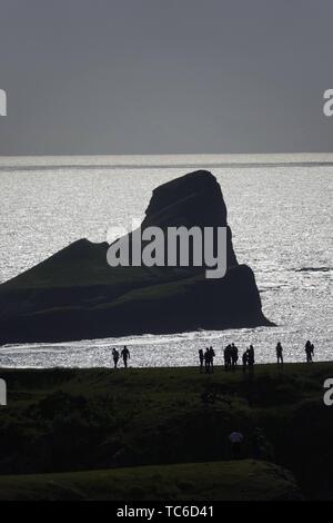 Gower, Swansea, Wales, UK. 5th June 2019. Weather: (note atmospheric distortion) Walkers and  sightseers enjoyed a beautiful sunny evening at National Trust Rhosili (correct,1's') on the Gower peninsula, south Wales. The headland and limestone clifftops afford spectacular views of Rhossili (correct, 2's') Bay and the iconic promontory of Worms Head. Showery conditions are forecast.  Credit: Gareth Llewelyn/Alamy Live News Stock Photo