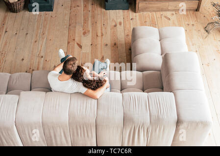 overhead view of couple embracing on sofa in living room