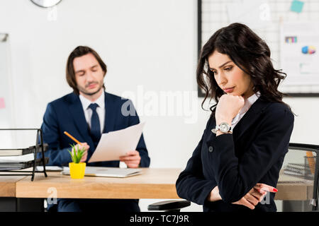 selective focus upset brunette woman sitting near handsome recruiter Stock Photo