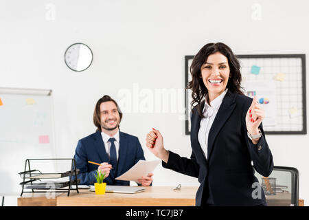 selective focus of cheerful woman looking at camera near handsome recruiter Stock Photo
