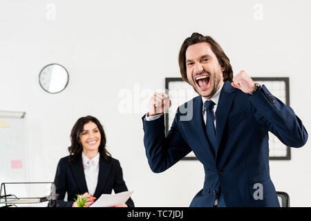 selective focus of happy man gesturing near attractive recruiter in office Stock Photo