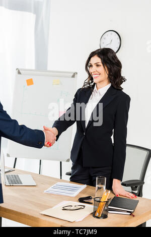 cropped view of man shaking hands with happy recruiter in office Stock Photo