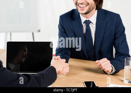 cropped view of cheerful man shaking hands with recruiter in office Stock Photo