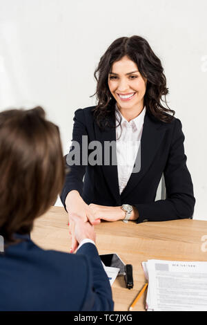overhead view of beautiful woman shaking hands with recruiter in office Stock Photo