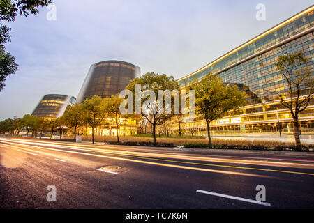 modern office building and traffic trails in urban city Stock Photo