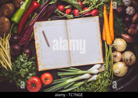 Vegetarian Raw Food Recipe. Blank Empty Cook Book Mockup with Fresh Vegetables. Healthy Eating Concept with Copy Space. Stock Photo