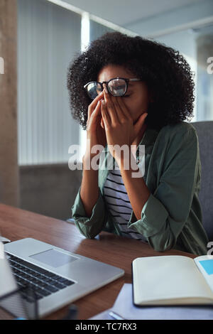 Portrait of a young tired businesswoman in office Stock Photo