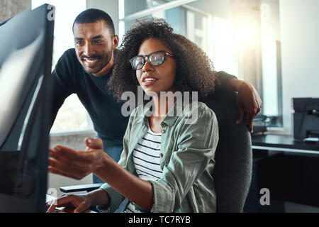 Businesswoman showing something to her colleague on computer Stock Photo