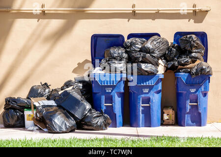 Miami Beach Florida,North Beach,trash cans cannisters bins Black plastic bags,overloaded,overflow,FL190430029 Stock Photo