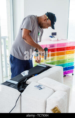 Miami Beach Florida,North Beach,West Elm furniture delivery,Black man men male,unpacking,assembling putting together sofa,FL190430066 Stock Photo