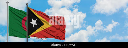 East Timor flag waving in the wind against white cloudy blue sky ...