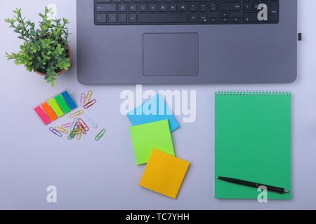 Close-up of comfortable working place in office with laptop, notebook, glasses, pen and other equipment laying on table with copy space. Top view. Stock Photo