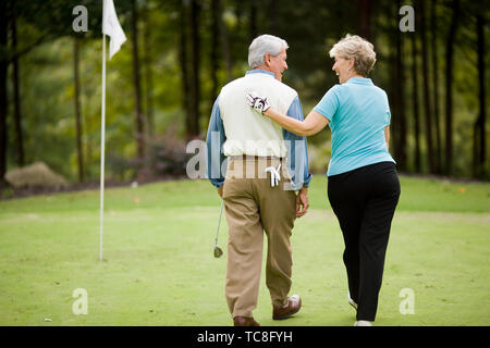 Older couple sharing a laugh on a golf course Stock Photo