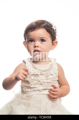 Vertical portrait of an 18-month old little girl with a bright red ...