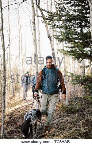 Man with dog hiking in woods