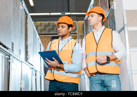 attentive multicultural colleagues working in tiles department in warehouse Stock Photo