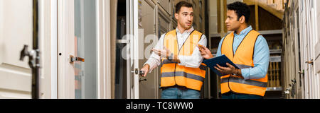 panoramic shot of multicultural storehouse workers talking in doors department Stock Photo