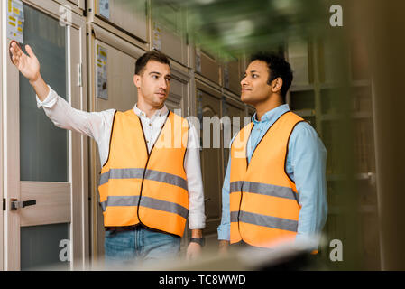 selective focus of multicultural workers talking while standing in doors department Stock Photo