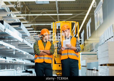 selective focus of concentrated workers using digital laptop in warehouse Stock Photo