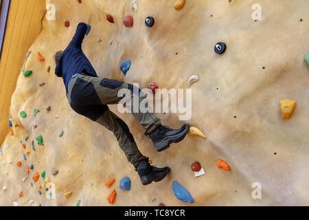 free climber practicing climbing on outdoor artificial rock wall Stock Photo