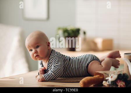 Cute child with big blue eyes waiting for his meal. Stock Photo