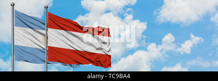 Argentina and Austria flag waving in the wind against white cloudy blue sky together. Diplomacy concept, international relations. Stock Photo