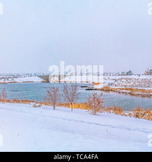 Frame Square Idyllic winter scenery with a calm silvery lake amid a snow covered landscape Stock Photo