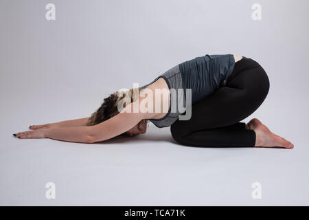 Ardha Kurmasana Half Tortoise yoga pose done by a woman Stock Photo