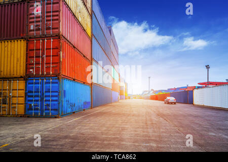 Empty road and containers in harbor at sunset Stock Photo