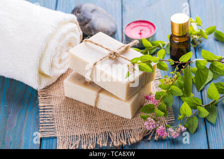 Healthy beauty spa, hand soap and essential oils and fresh flowers on blue table Stock Photo