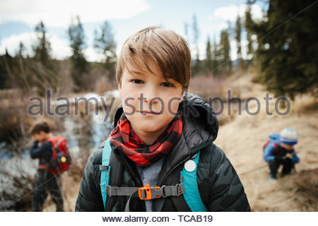 Portrait confident boy hiking with brothers in woods
