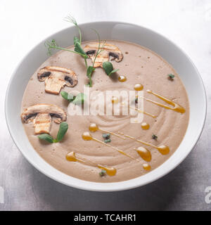 Cream soup with mushrooms, mushrooms and potatoes in a white bowl Stock Photo