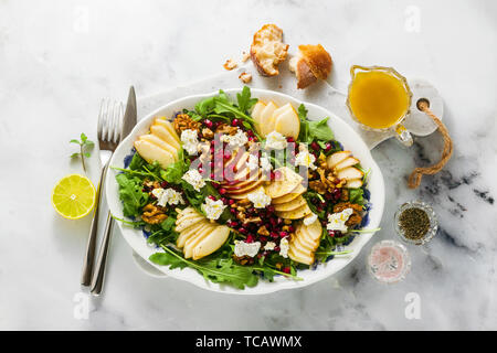 Pomegranate & Pear Green Salad with Ginger Dressing on white marble . healthy breakfast or lunch Stock Photo