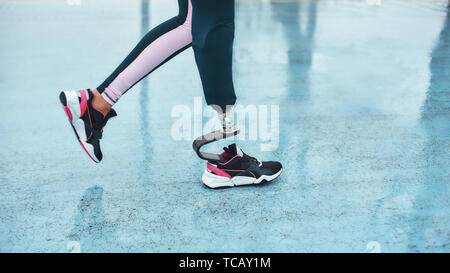Disabled athlete. Cropped image of female legs with prosthesis walking outdoors. Sport concept. Disabled Sportsman Stock Photo