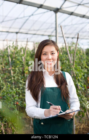 young beautiful asian woman works in green field Stock Photo