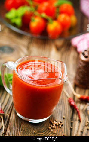 tomato sauce in glass jug and on a table Stock Photo