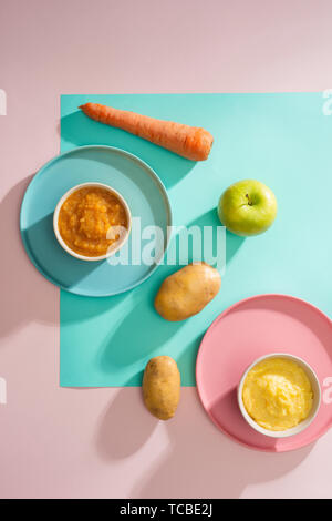 Bowls with baby food. Various bowls of fruit and vegetable puree with ingredients for cooking Stock Photo