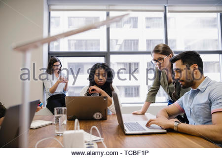 Business people using laptops in conference room meeting