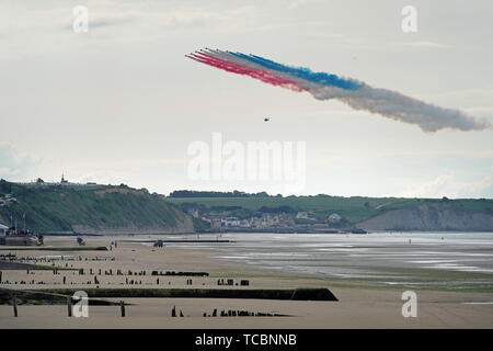 The RAF's Red Arrows fly over the beach at Arromanches, in Normandy, northern France, during a ceremony to commemorate the 75th anniversary of the D-Day landings. Stock Photo