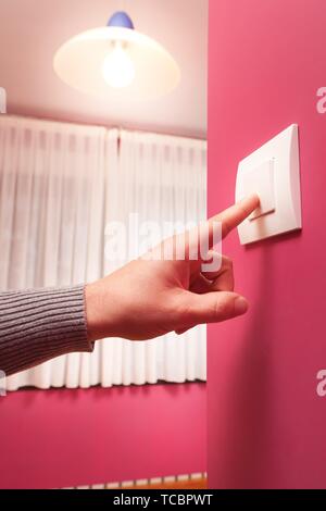a man pressing a wall switch Stock Photo - Alamy