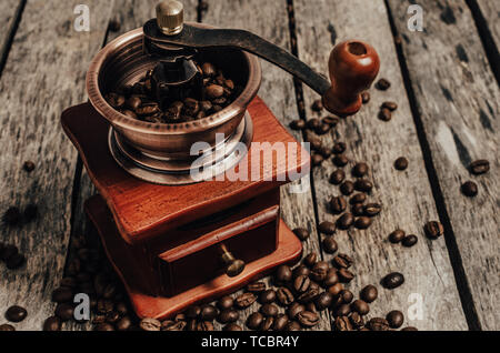 Hand coffee grinder with coffee beans on wooden background. Stock Photo
